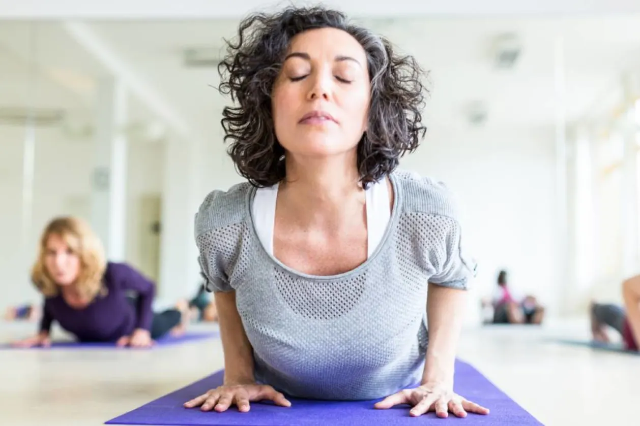 Woman practicing upward facing dog in yoga class